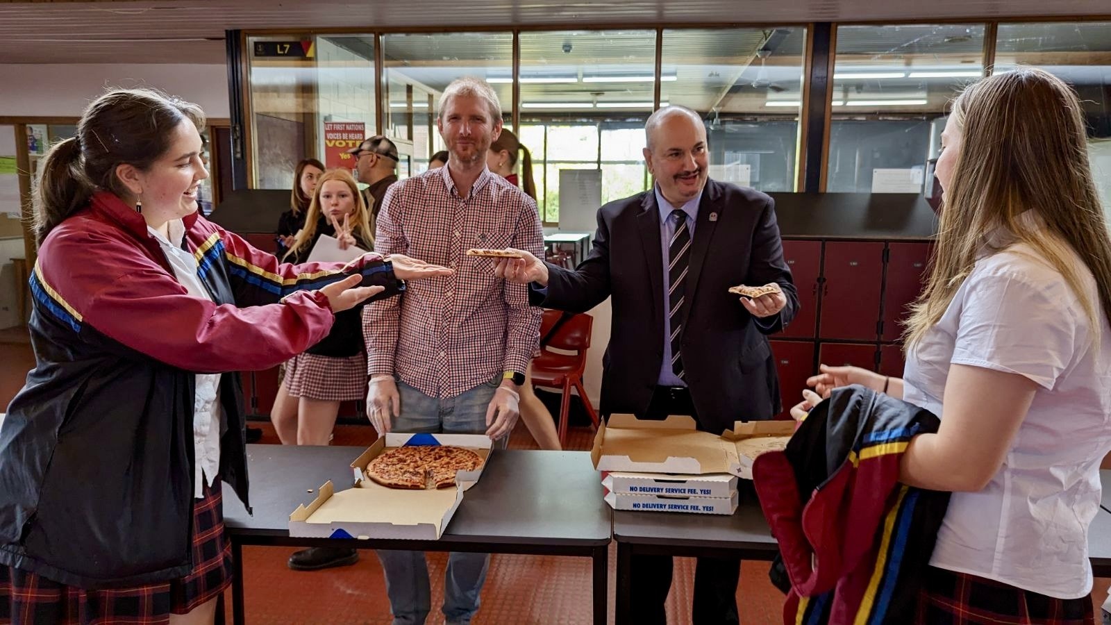 The final slices of pizza being handed out to Year 11s by Mr Catalano at the Pizza Party