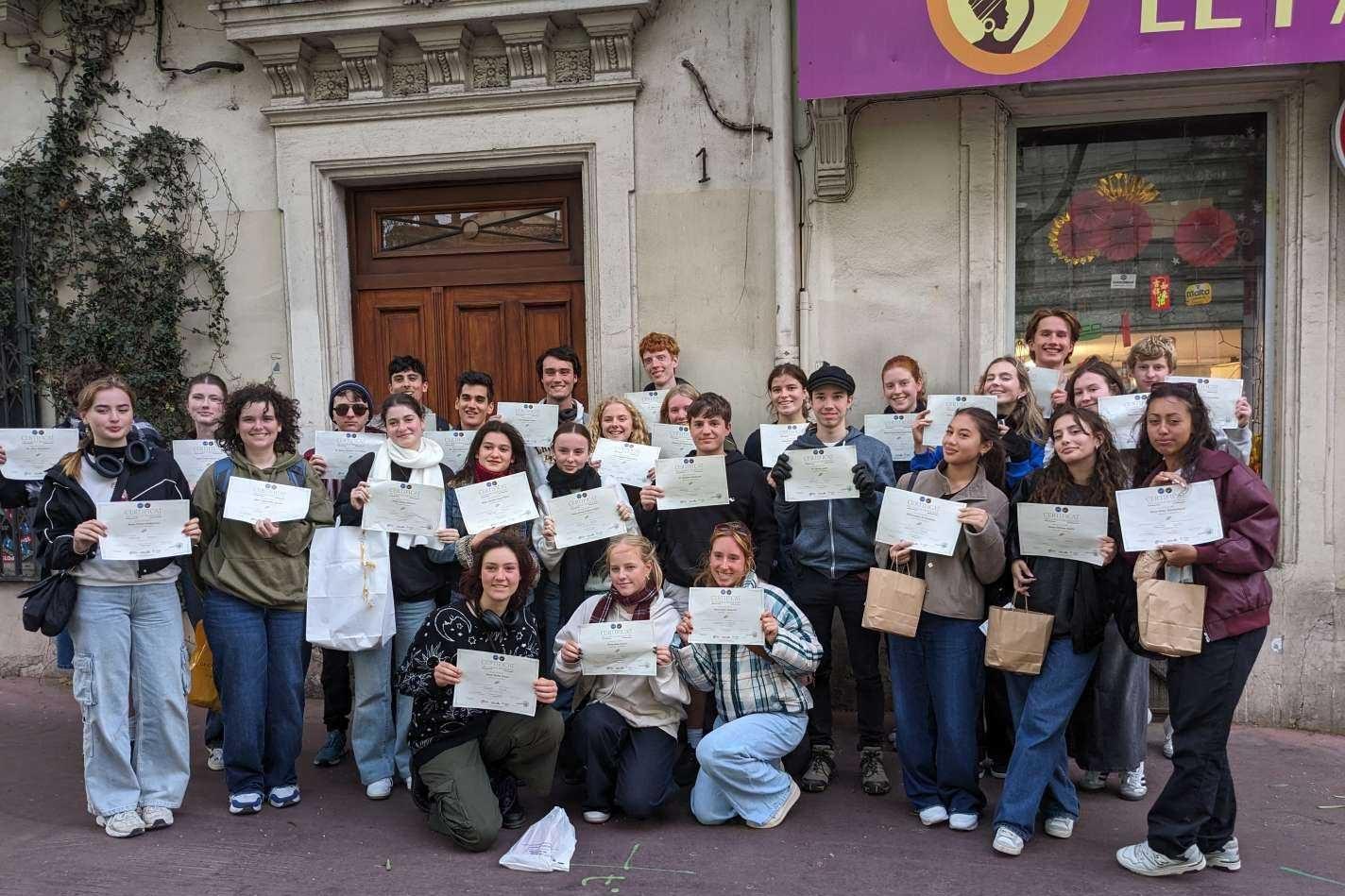 France Study Tour - students holding their degrees obtained at the French school